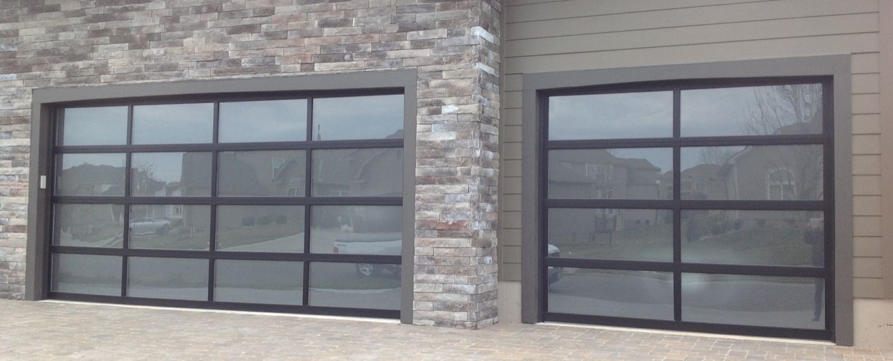 A pair of garage doors with a brick wall in the background.