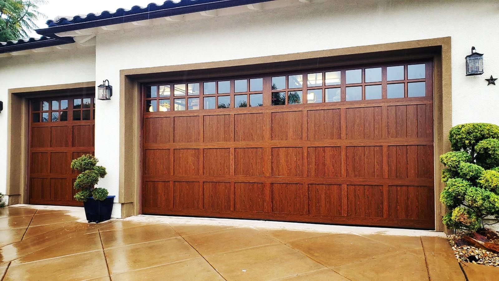 A white house with two wooden garage doors.