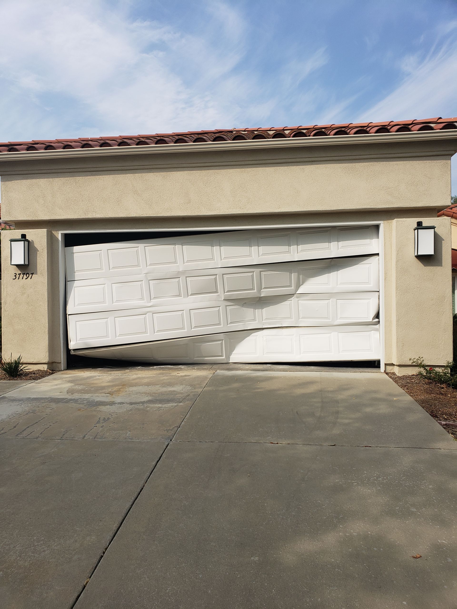 A garage door that has been damaged by a storm
