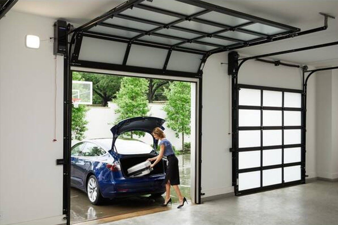 A woman is loading a car into a garage door.
