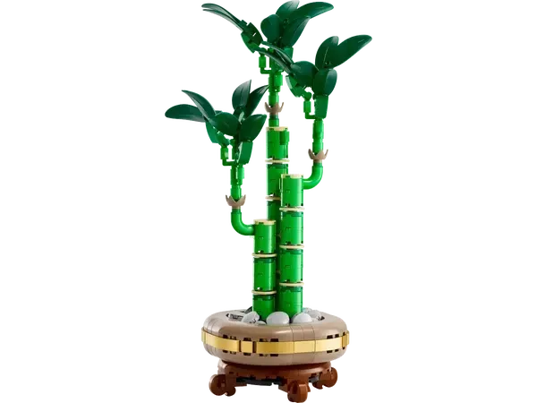 LEGO bonsai tree with green bamboo stalks, leaves, and a brown pot with white stones.