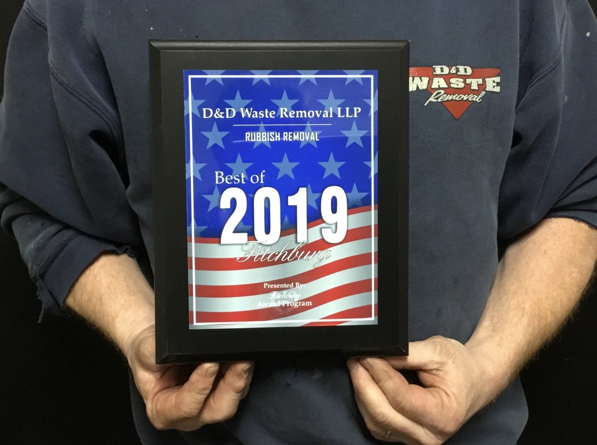 A man is holding a framed plaque that says best of 2019