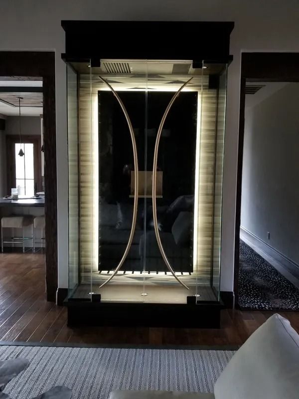 Indoor water feature with decorative metal arcs and backlighting.