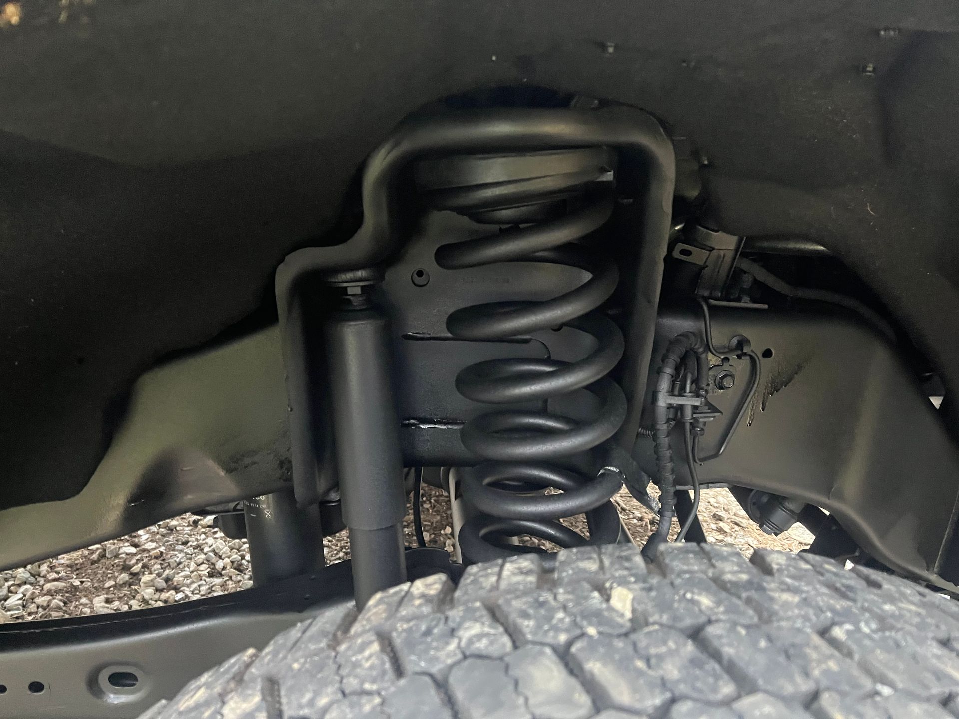 Black truck chassis with leaf spring suspension and mounting hardware.