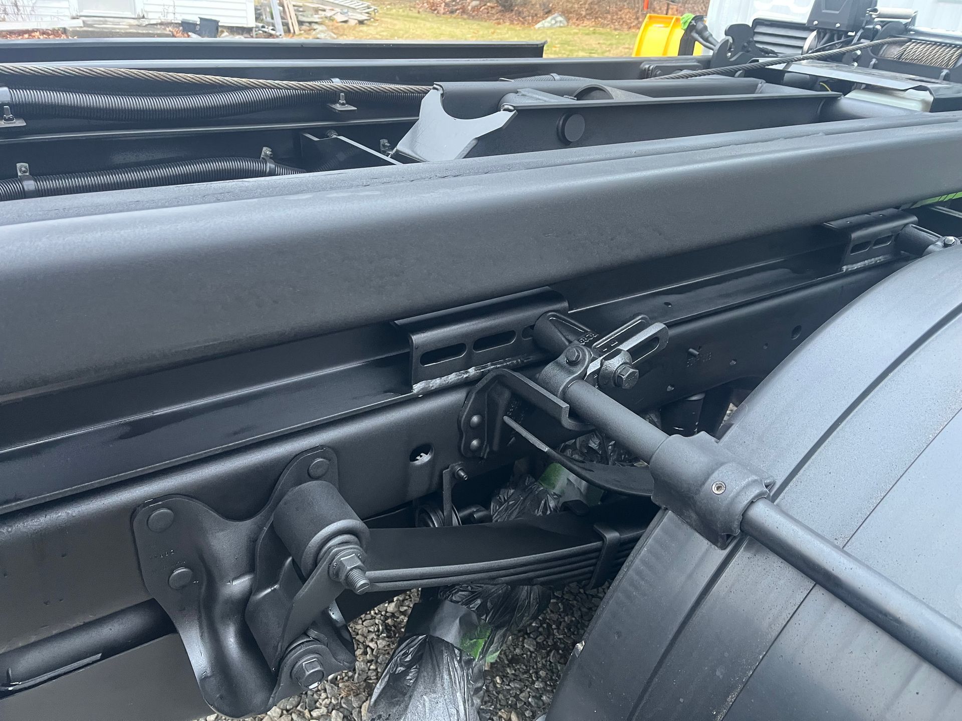 Black truck chassis with suspension and leaf springs visible.