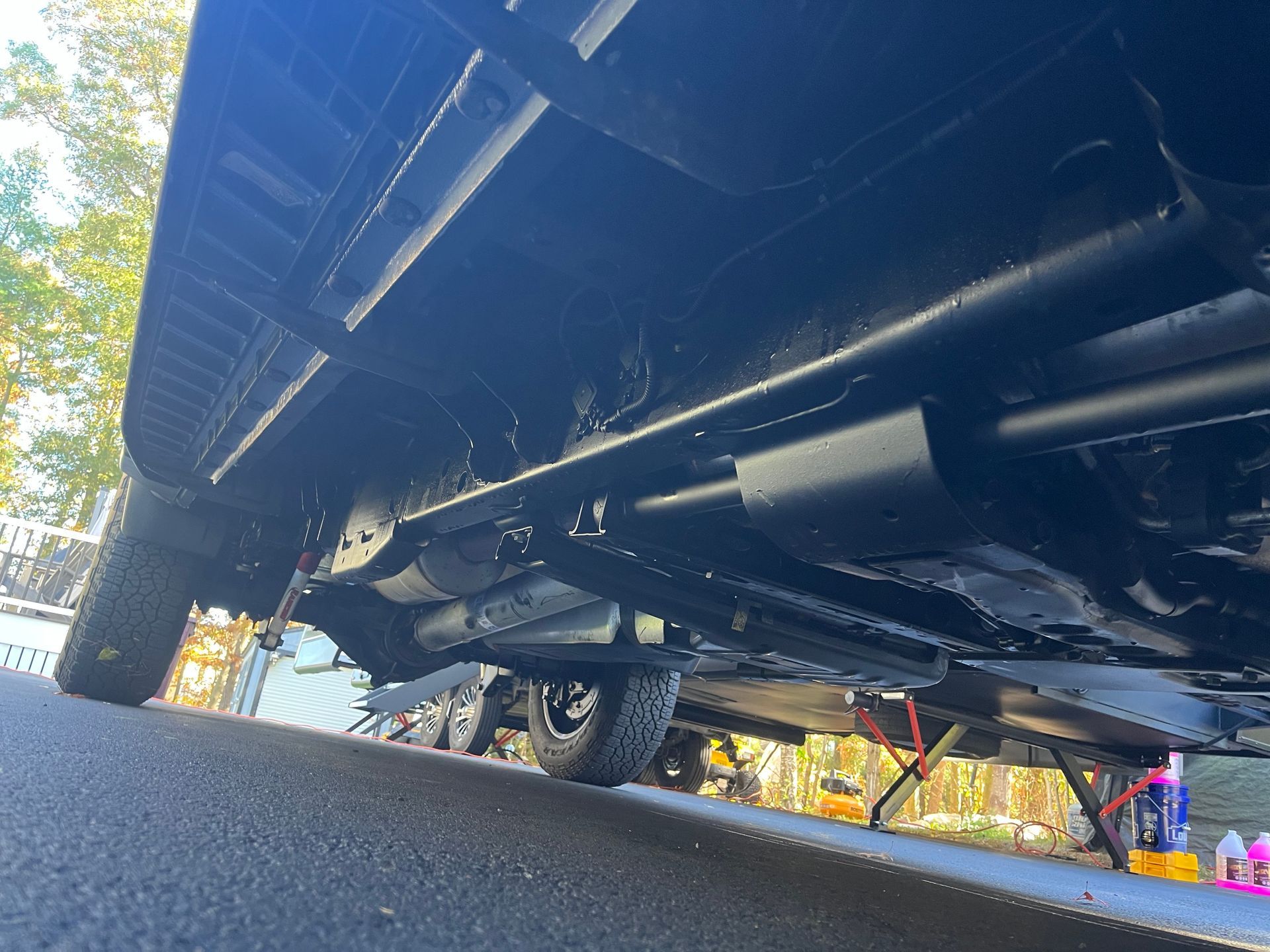 Undercarriage of a black vehicle, viewed from below, showing exhaust and frame painted black.