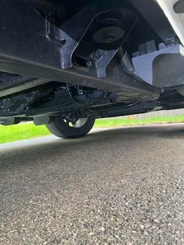 A close up of the underside of a car parked on the side of the road.