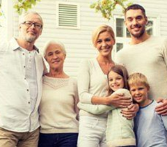 A family is posing for a picture in front of a house