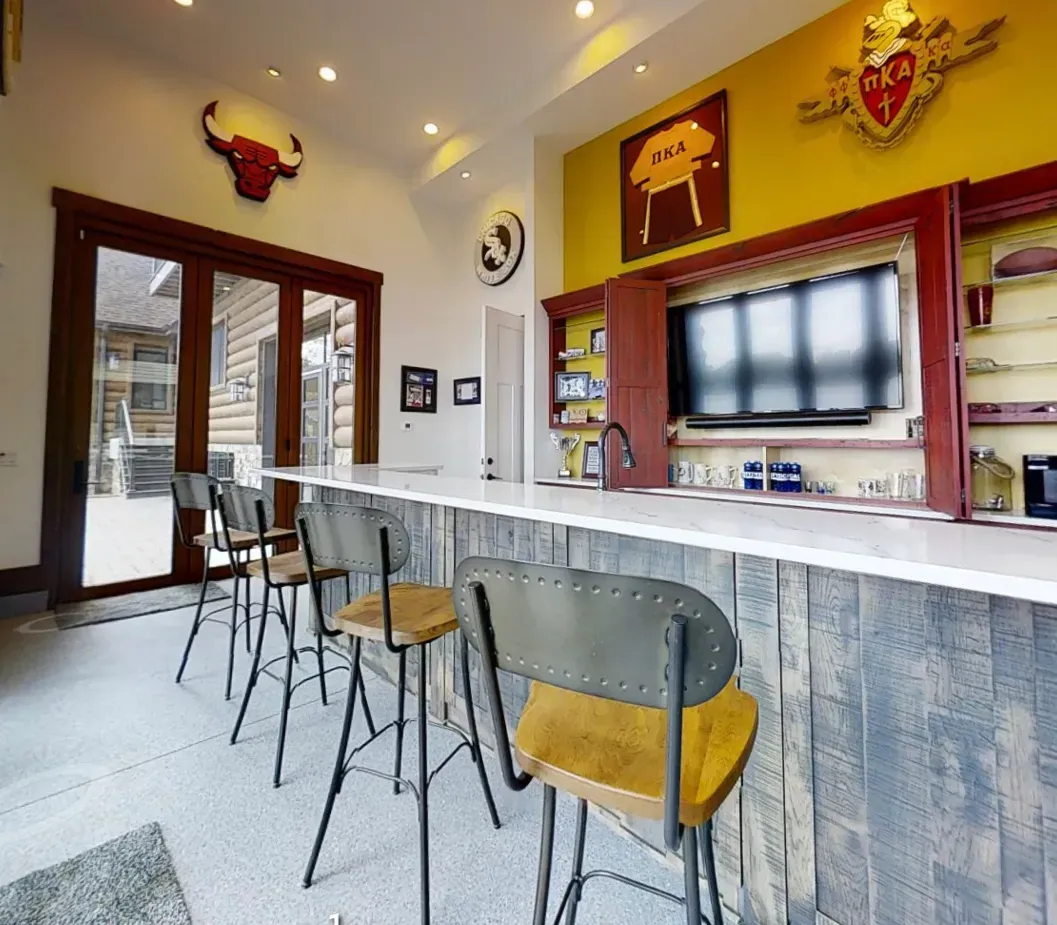 Modern cafe interior with bar stools, white marble counter, and yellow walls decorated with bull art.