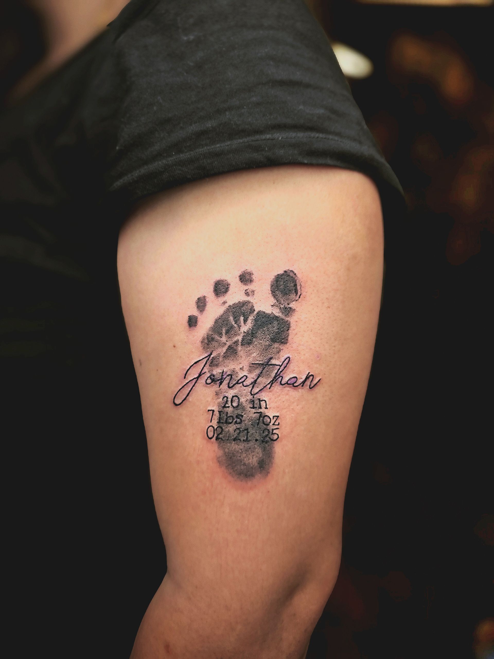 Tattoo of a baby footprint with the name 