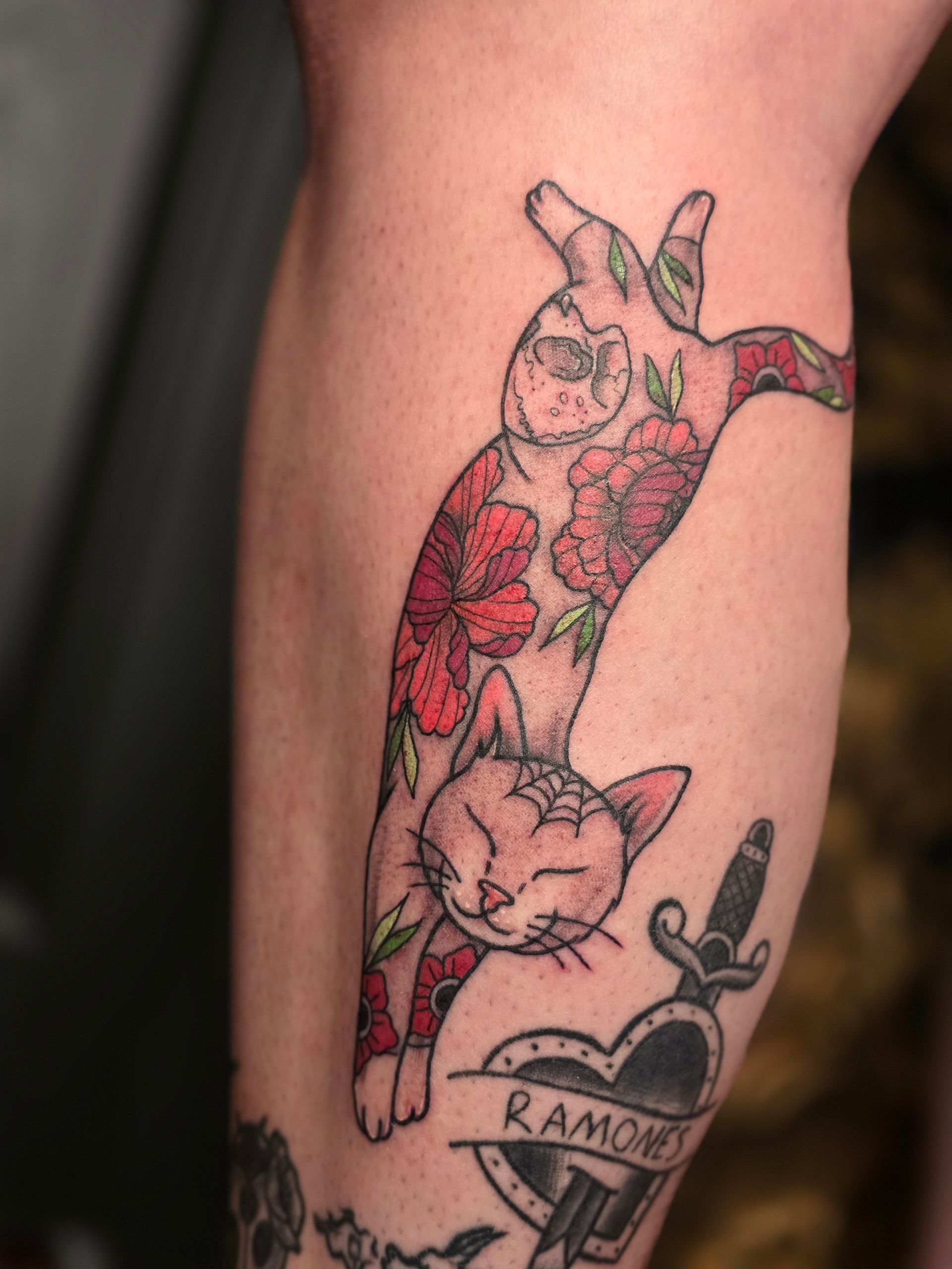 Tattoo of a cat with red floral pattern, heart with 