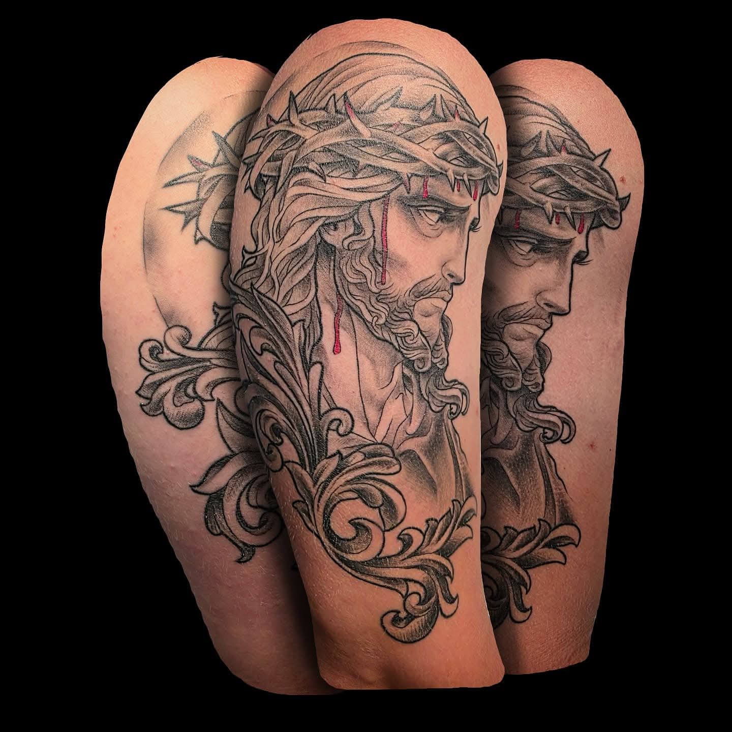 Tattoo on the arm of Jesus wearing a crown of thorns, with elaborate scrollwork and a contemplative expression.