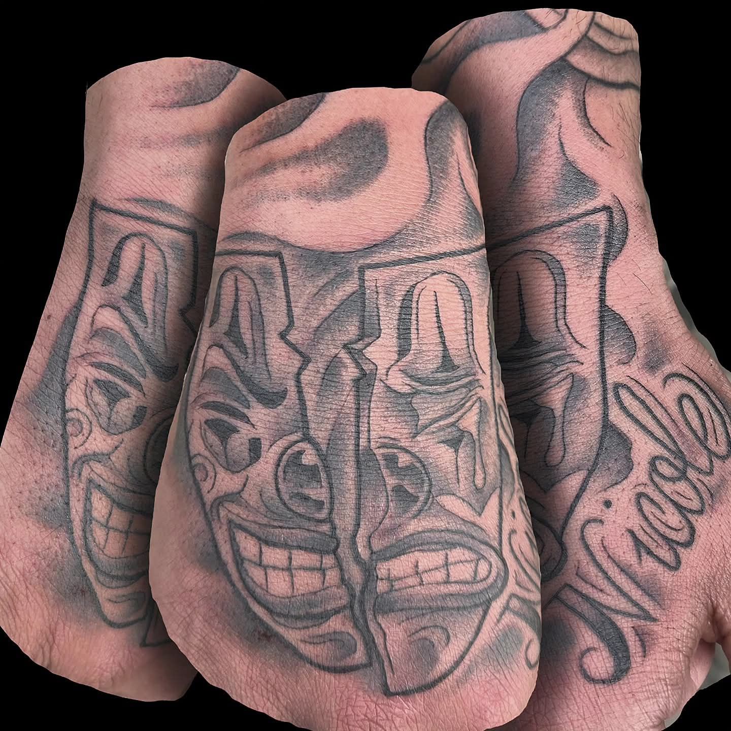 Hand tattoos, laughing and crying theater masks, name 