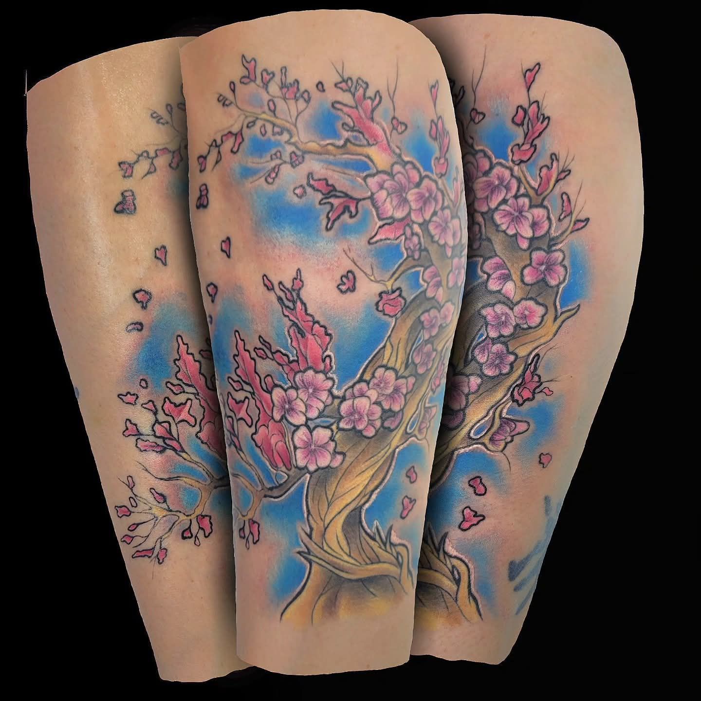 Tattoo of a flowering cherry tree on a forearm, with pink blossoms against a blue background.
