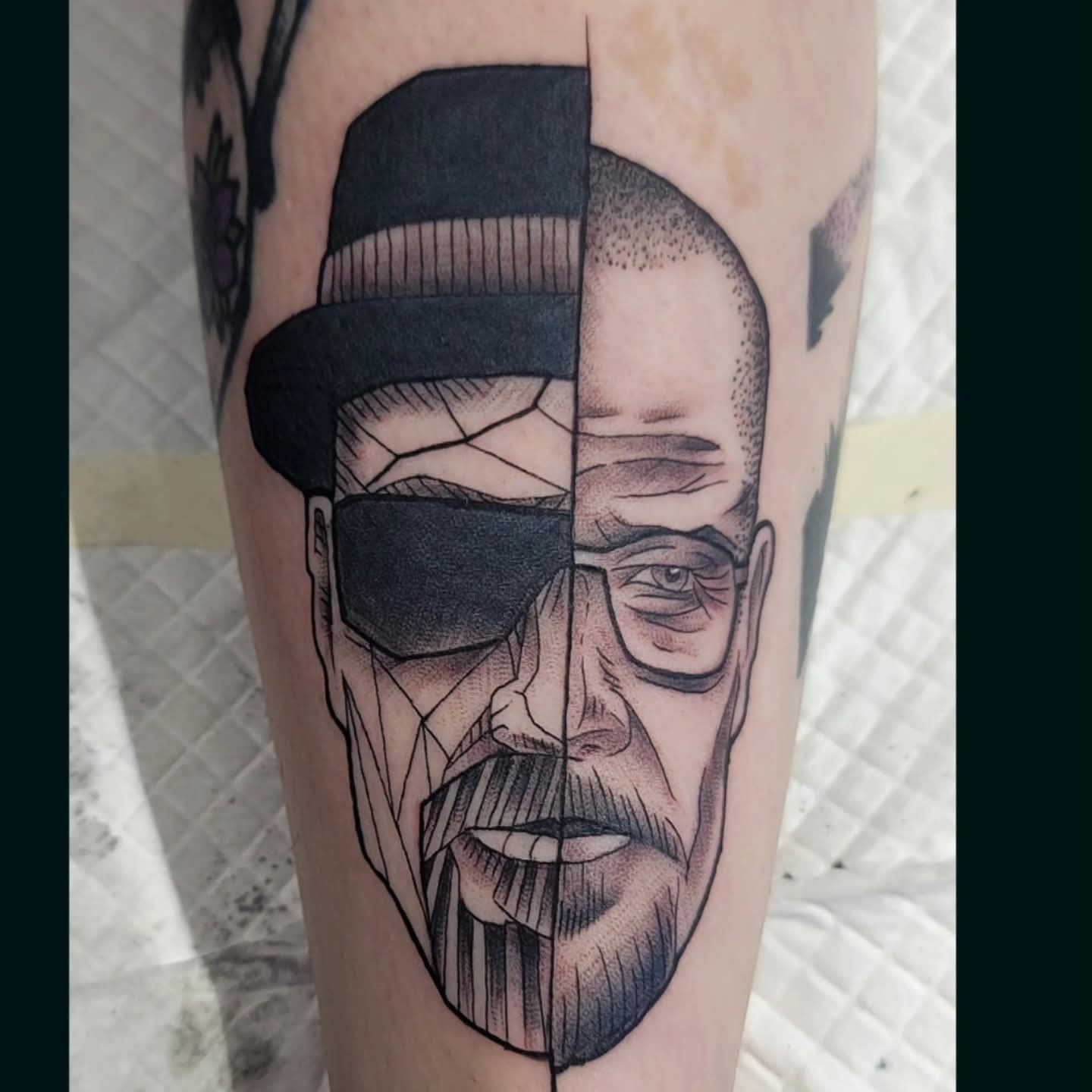 Tattoo of a split face: One side is Walter White wearing a hat, the other side is a man with glasses and a beard.