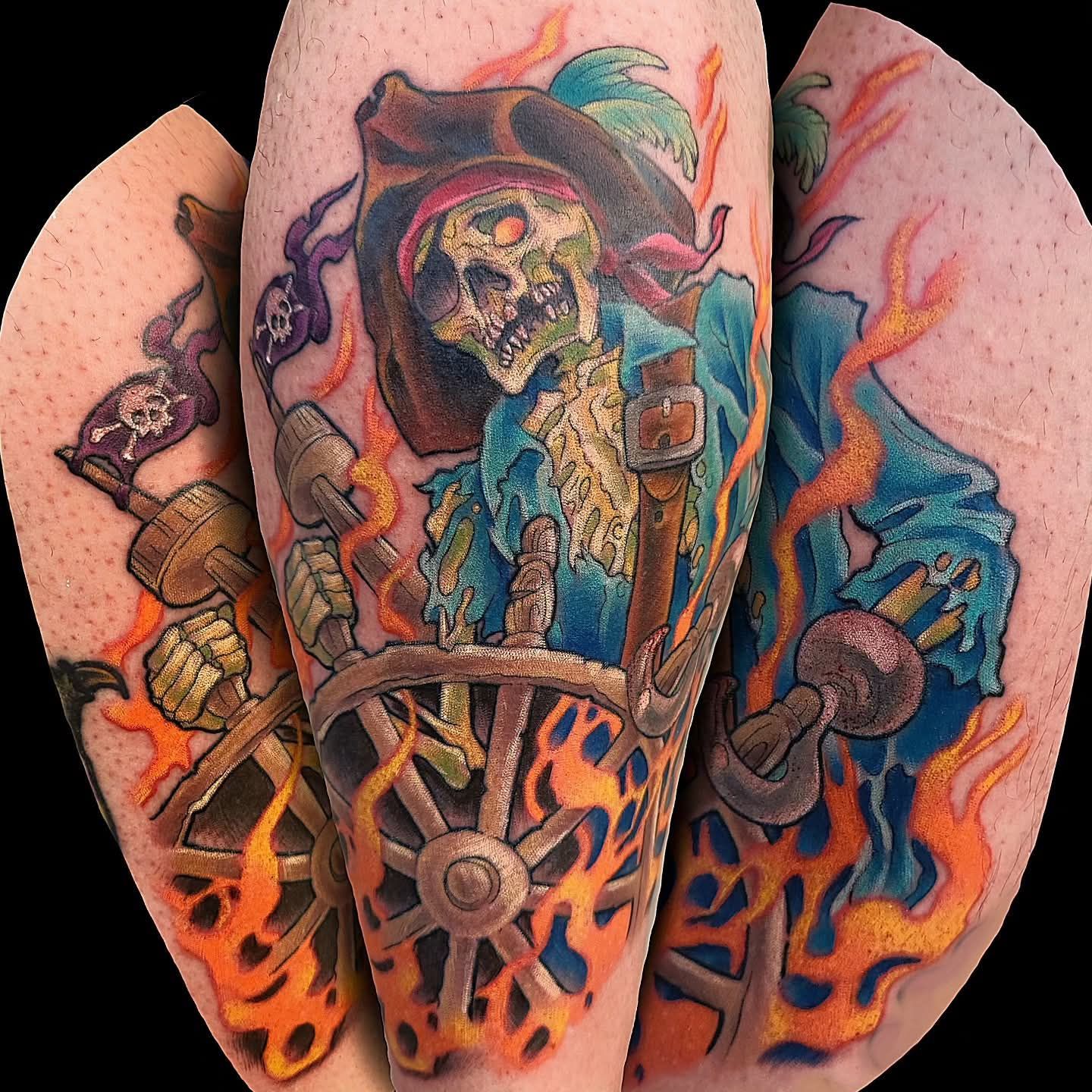 Tattoo of a skeletal pirate at a ship's wheel, surrounded by orange flames.
