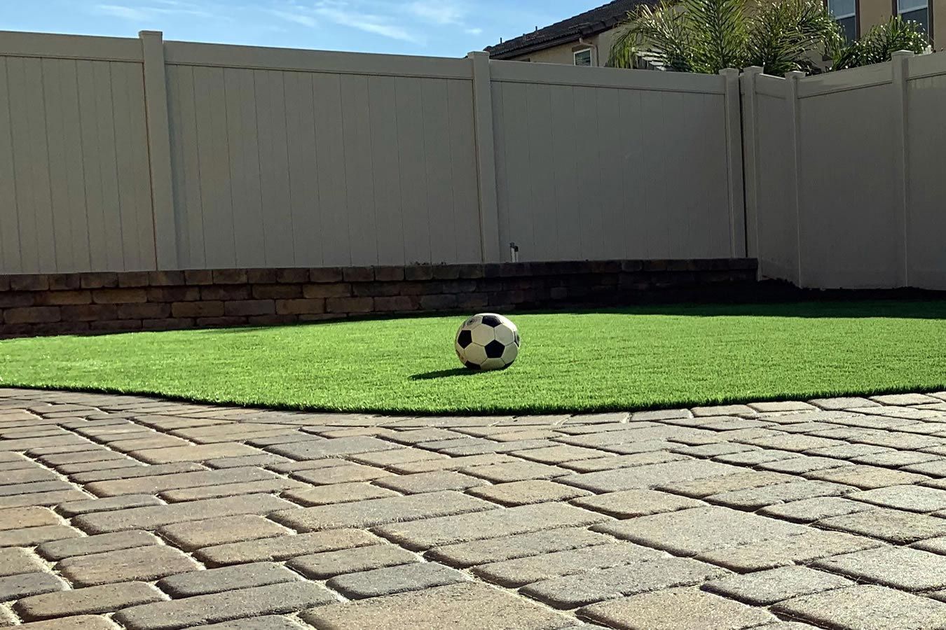 A soccer ball is sitting on top of a lush green lawn.