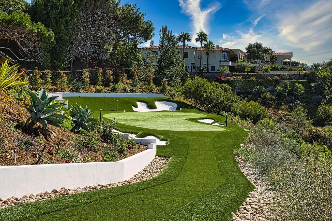 A lush green golf course with a house in the background