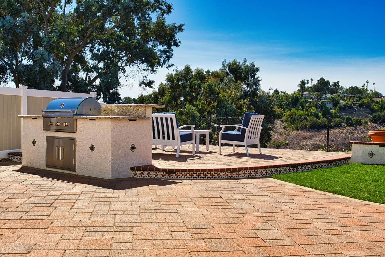 A patio with a grill and chairs on it