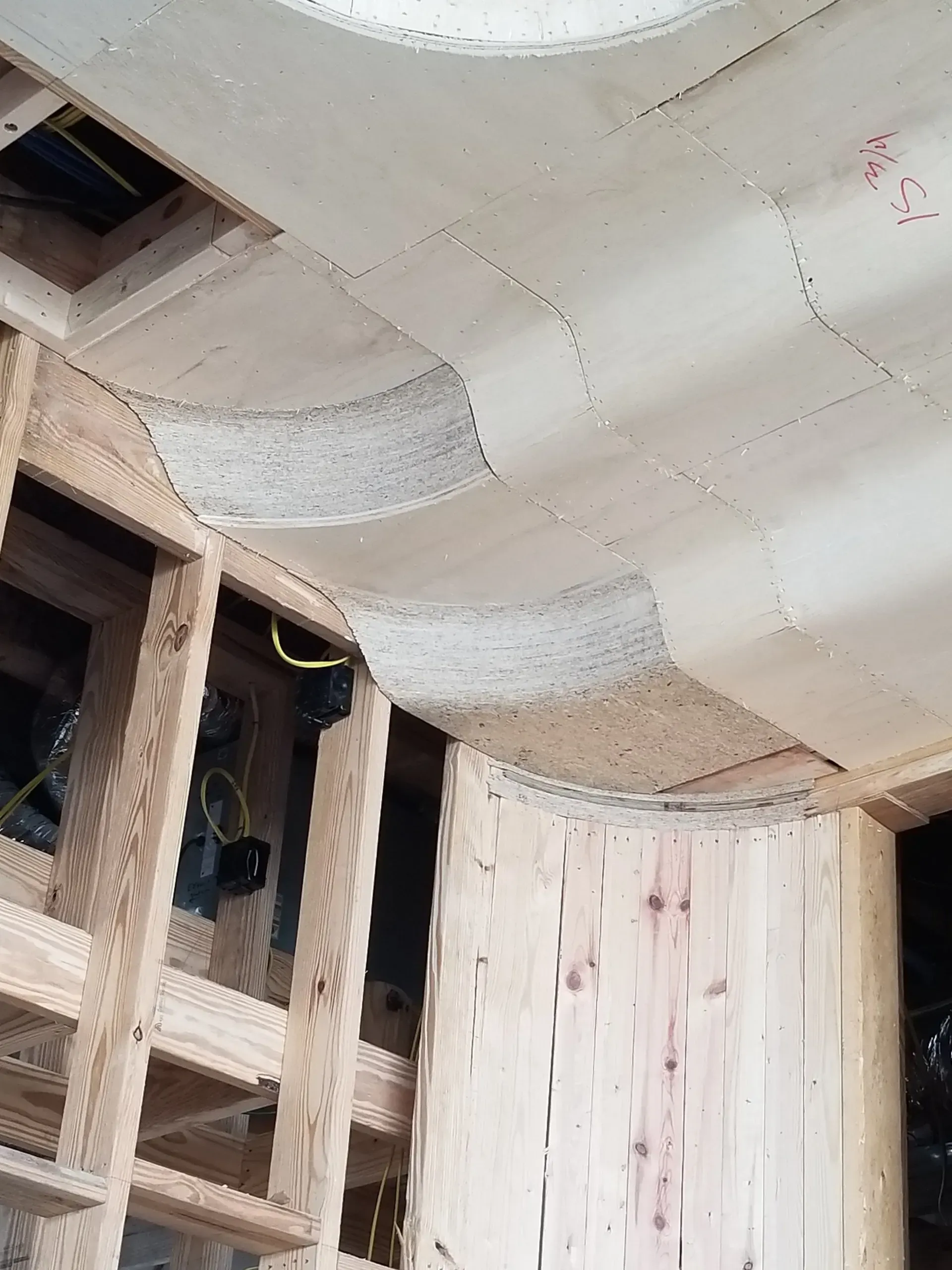 Partial construction site with exposed wooden framing and white insulated ceiling panels.