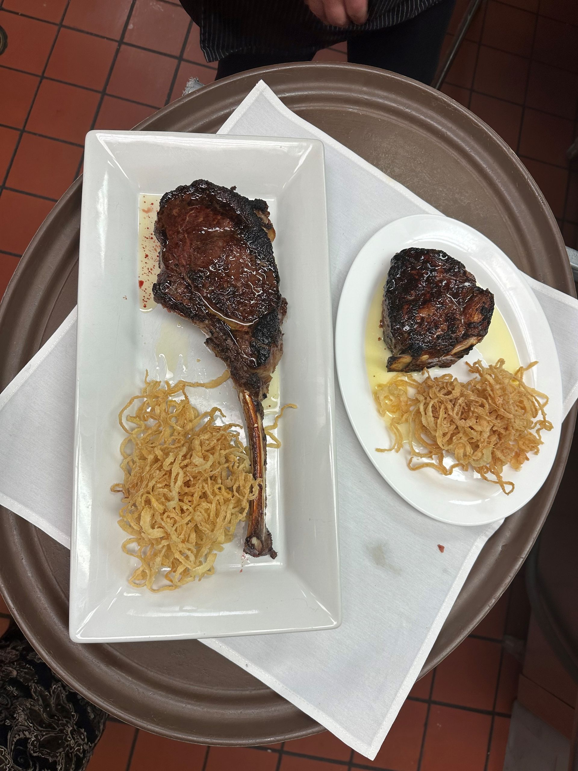 two plates of food are on a tray on a table .