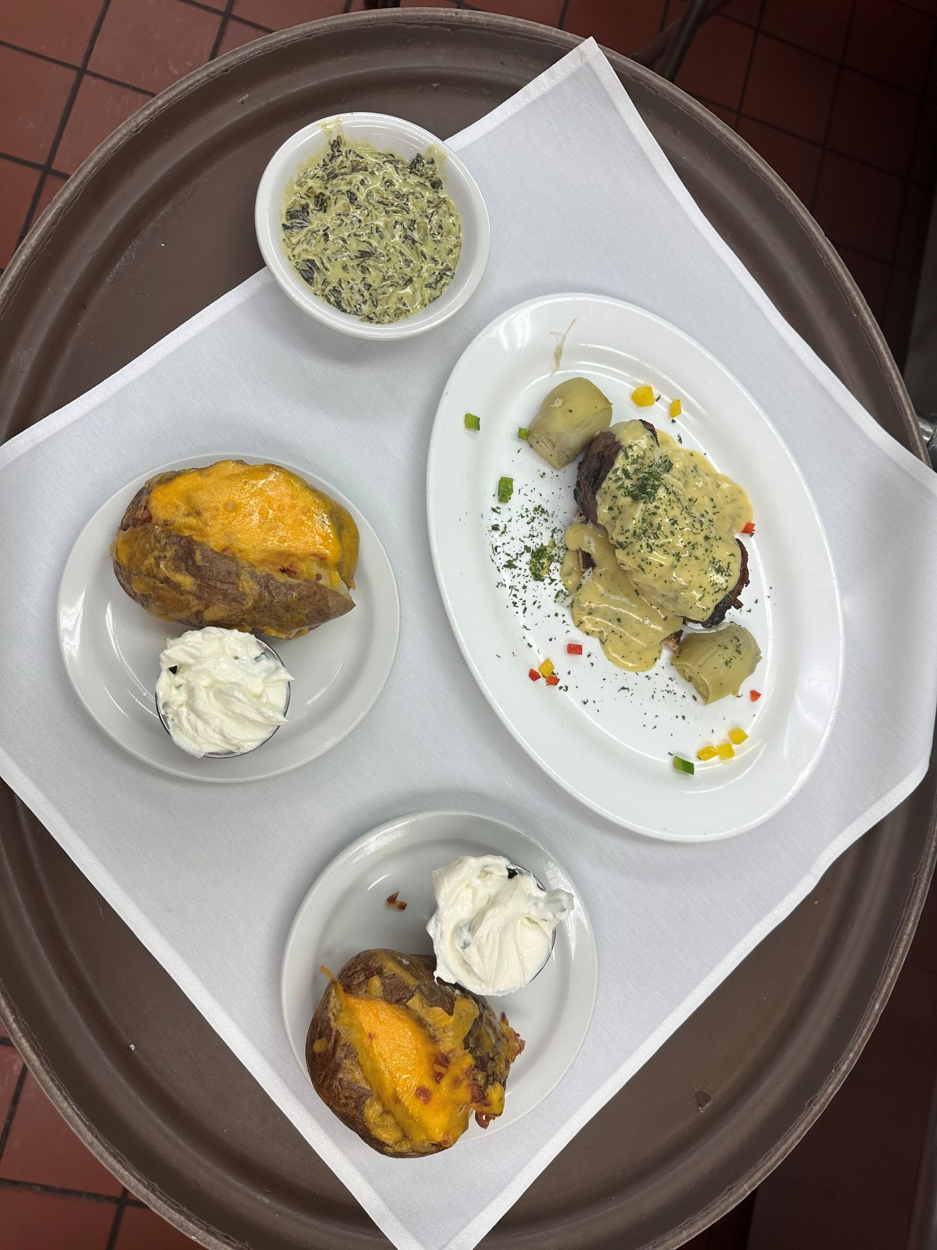 three plates of food are on a tray on a table .