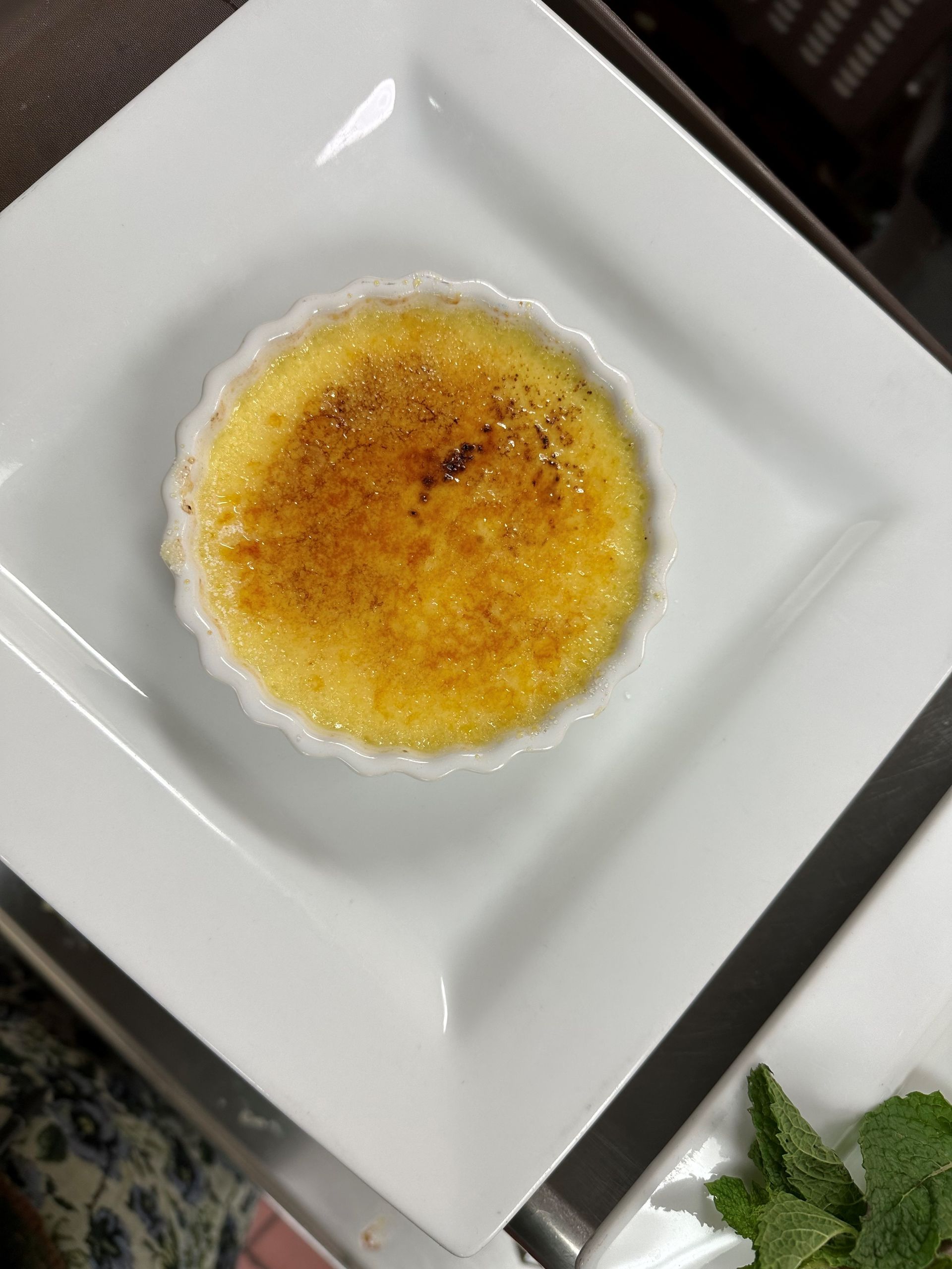 A white plate topped with a small dessert on a table.