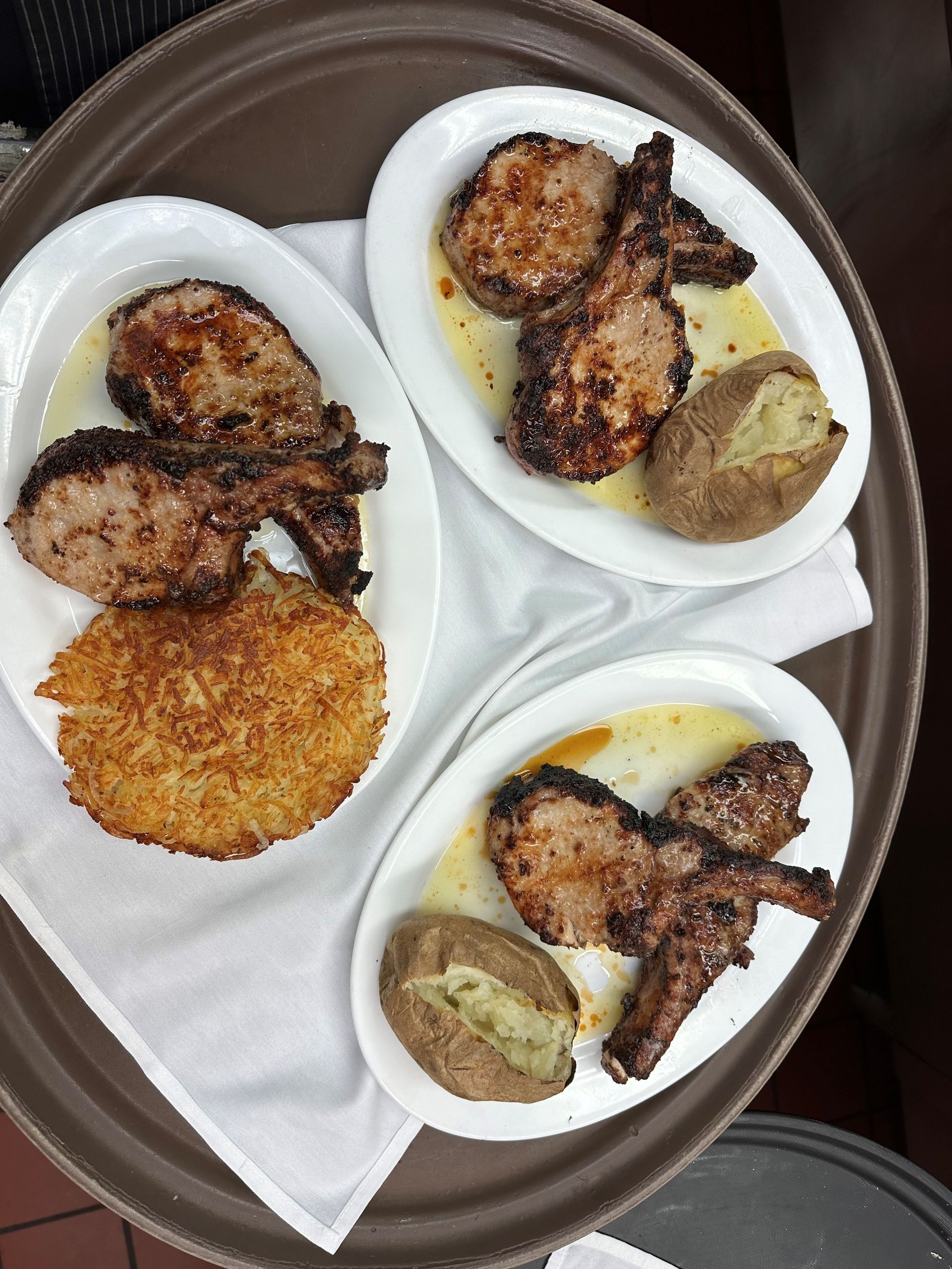 Three plates of meat and potatoes on a tray