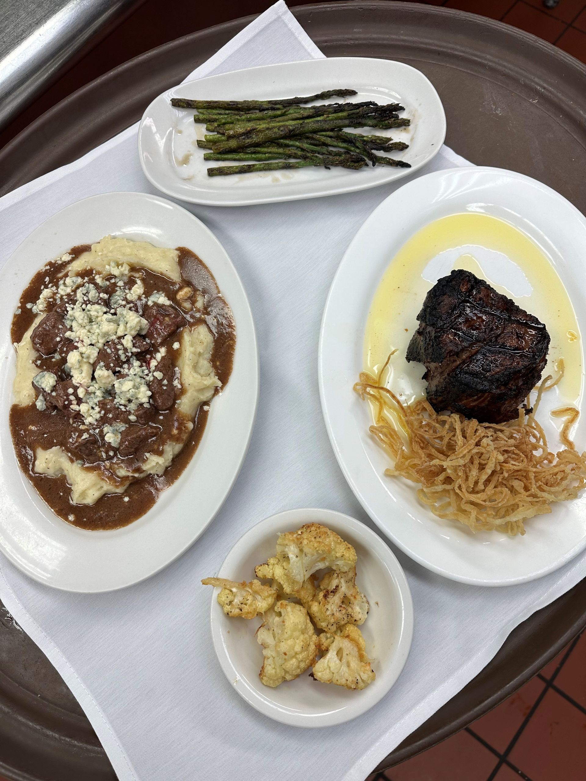 A tray of food with mashed potatoes and asparagus on it
