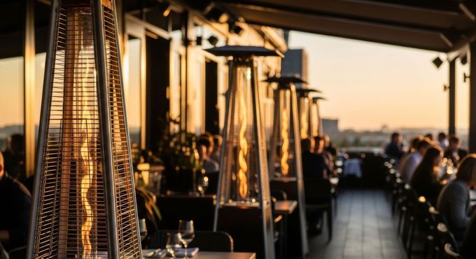 Outdoor restaurant patio with heated lamps at sunset, overlooking the water