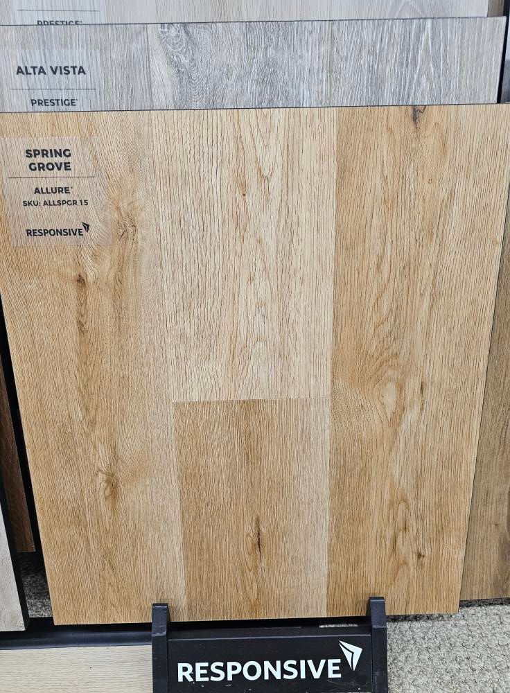 Wood-look flooring sample in light brown tones, labeled "Spring Grove" and "Responsive."