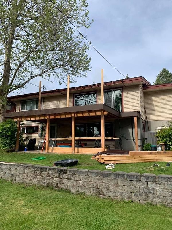 The back of a house with a wooden deck being built.
