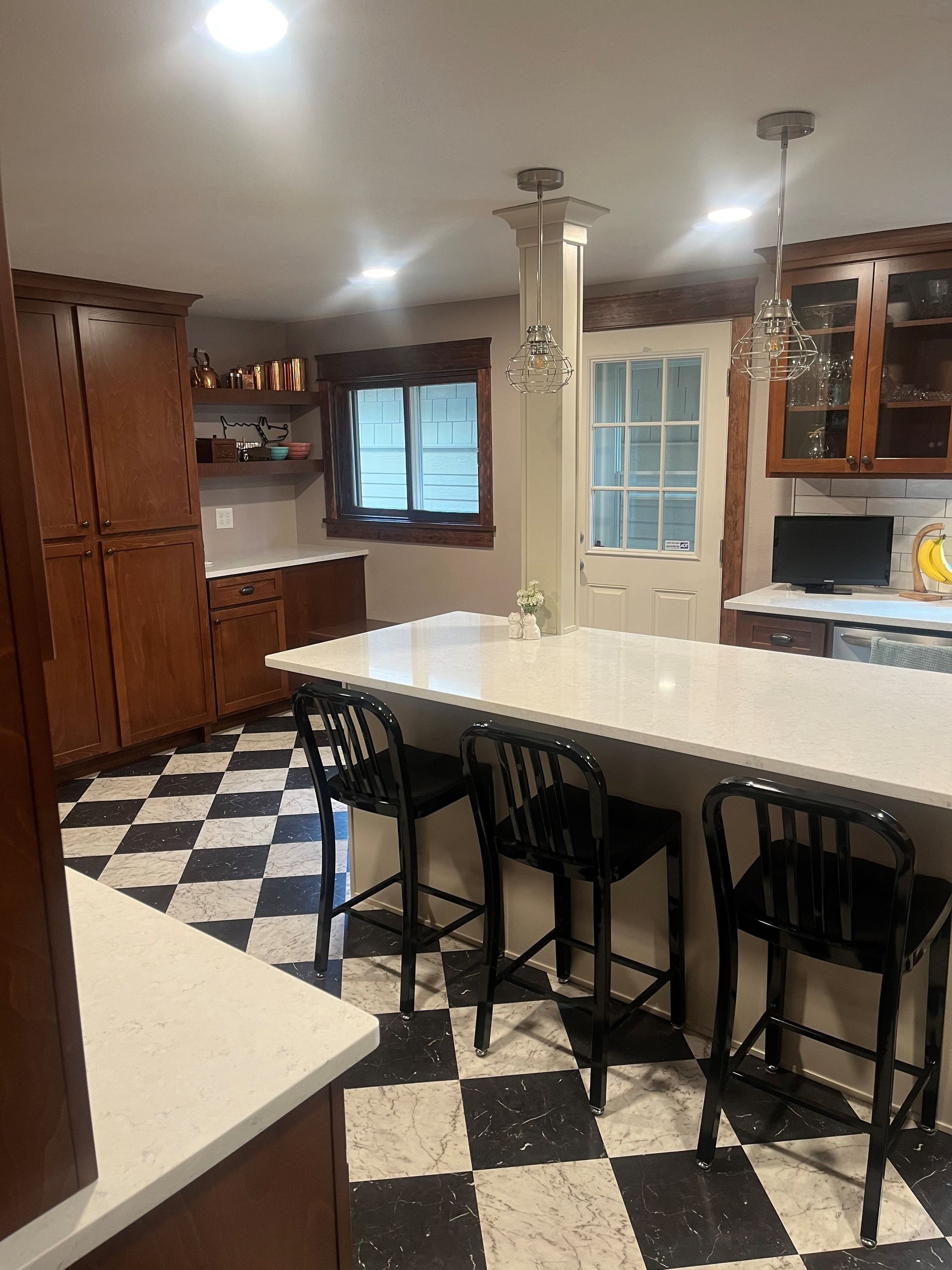 A kitchen with a checkered floor and a long table