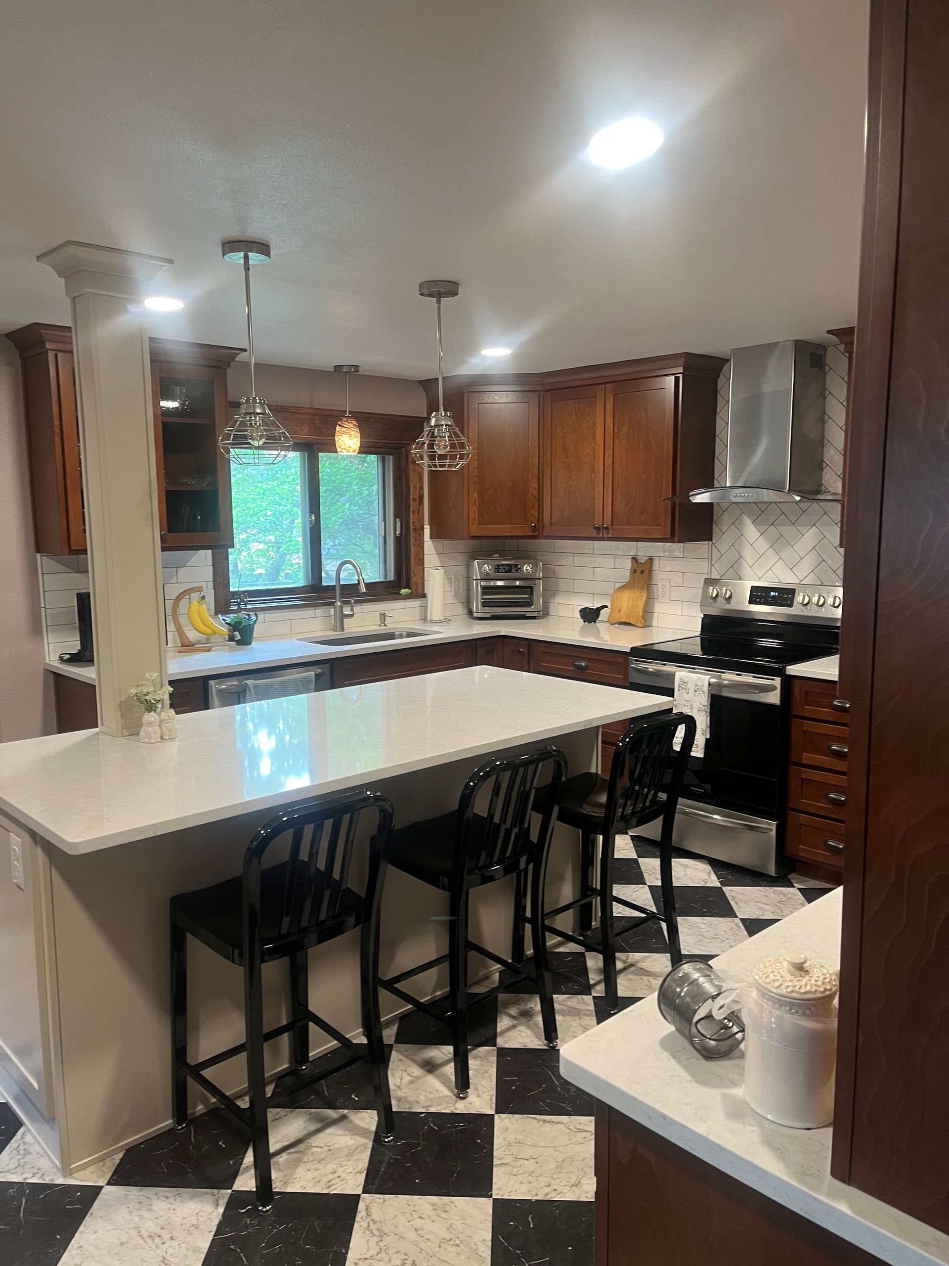 A kitchen with a checkered floor and a large island.