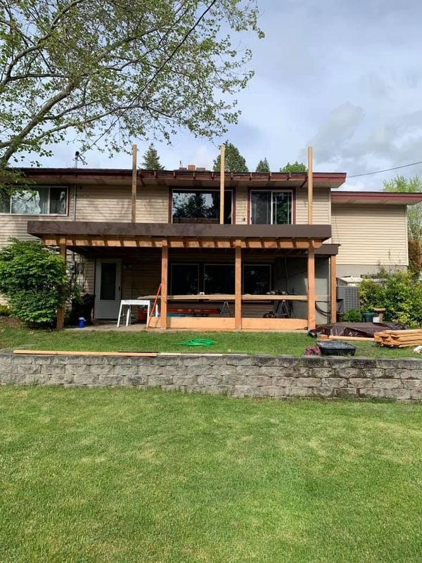 The back of a house with a wooden deck being built.