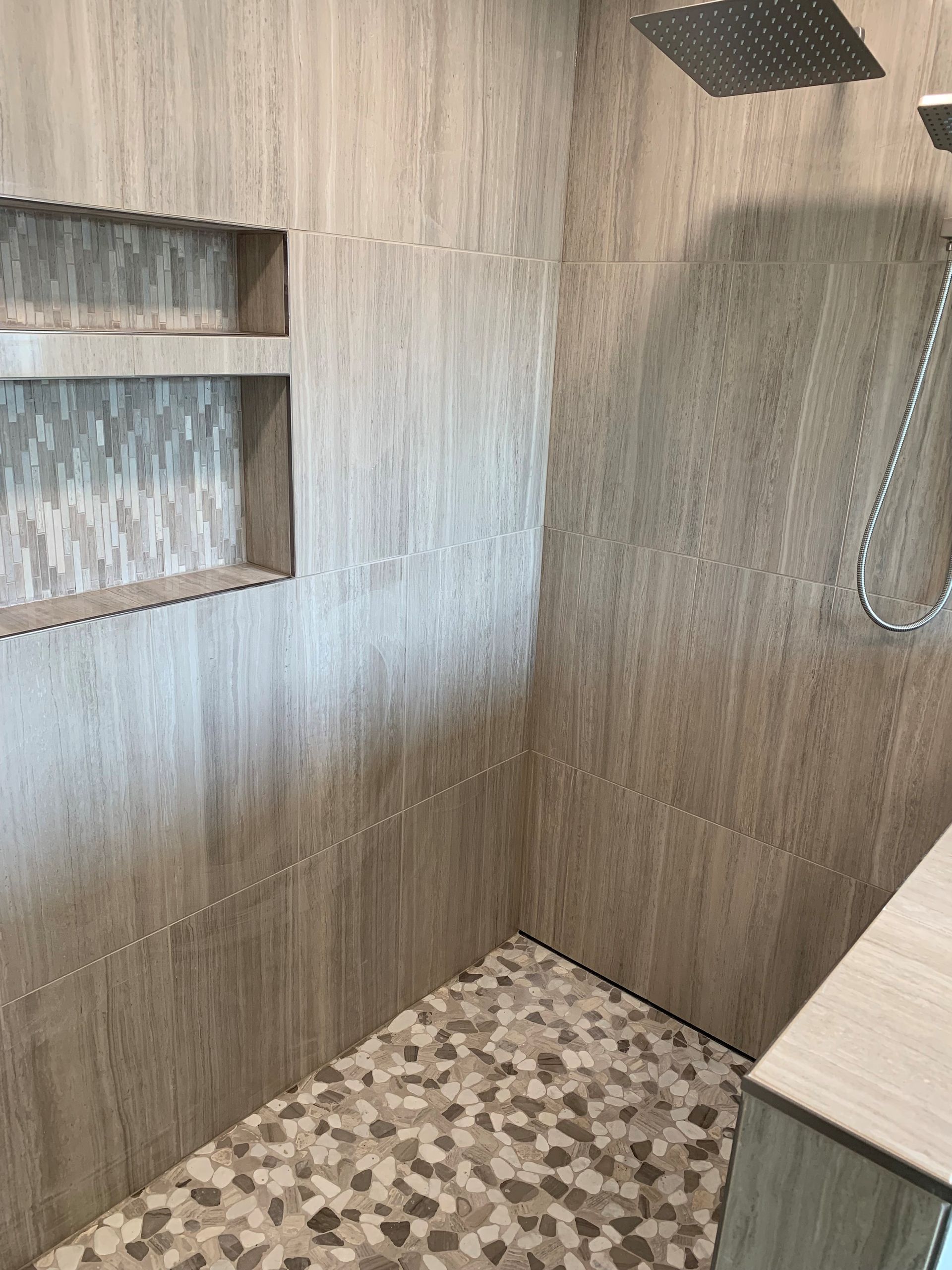 A bathroom with a walk in shower and a shower head.