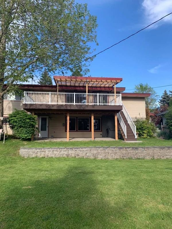 The back of a house with a large deck and stairs.