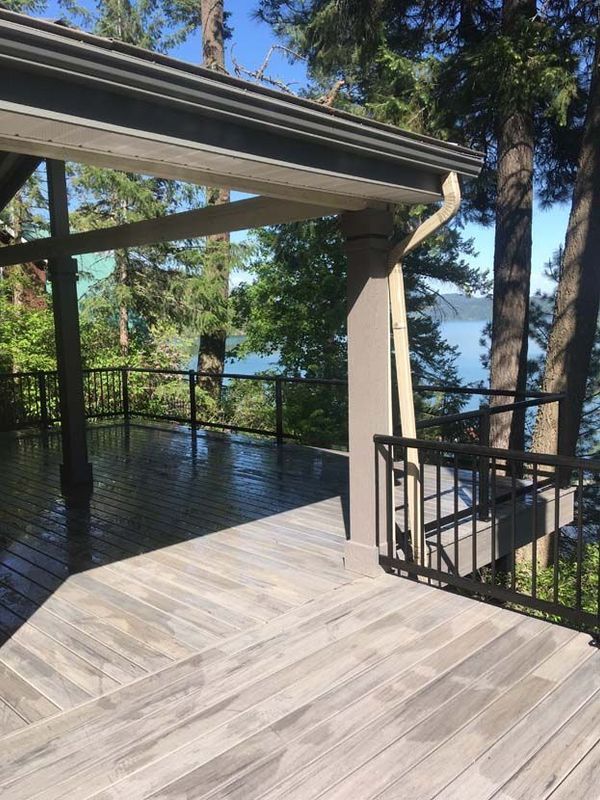 A wooden deck with a railing overlooking a body of water