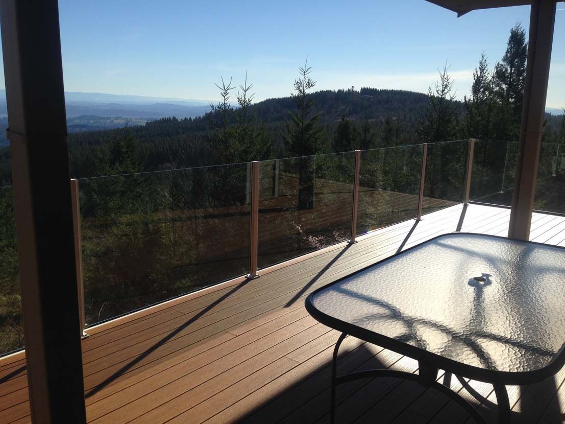 A deck with a table and chairs and a view of the mountains