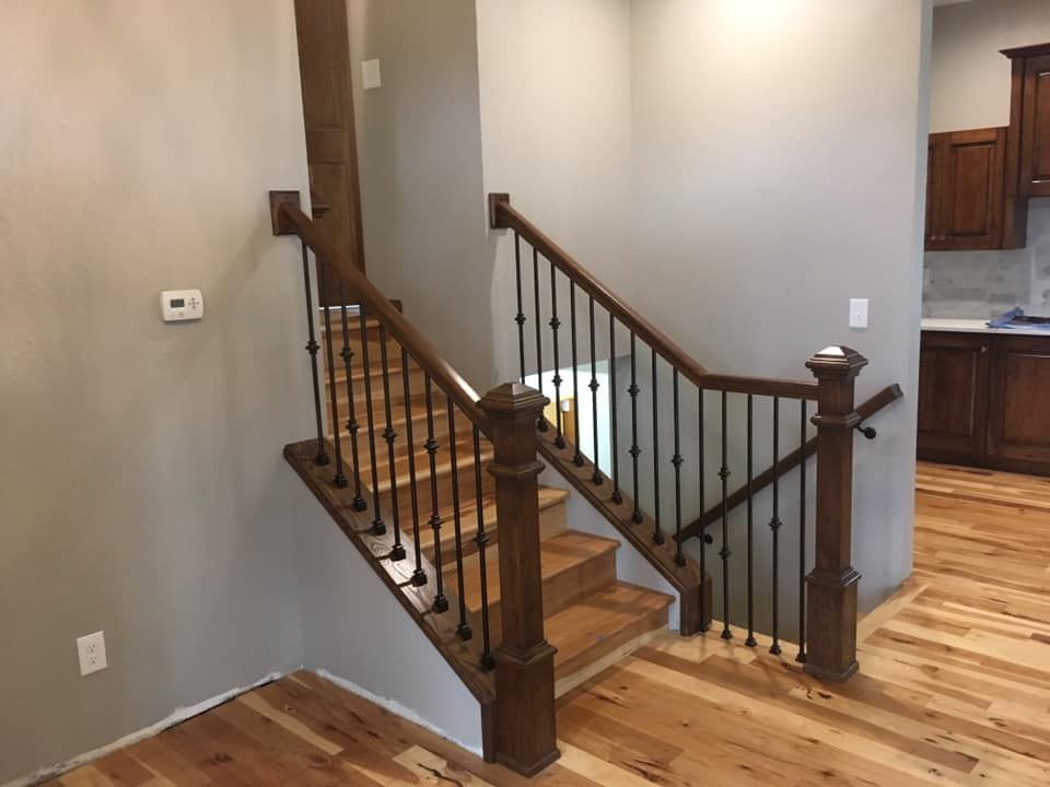 A wooden staircase with a metal railing in a house.