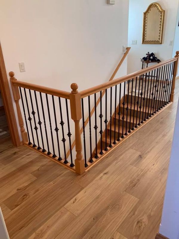 A wooden staircase with a metal railing and a wooden floor.