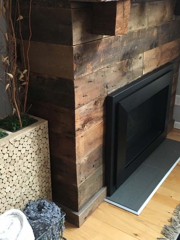 A fireplace with a wooden mantle in a living room
