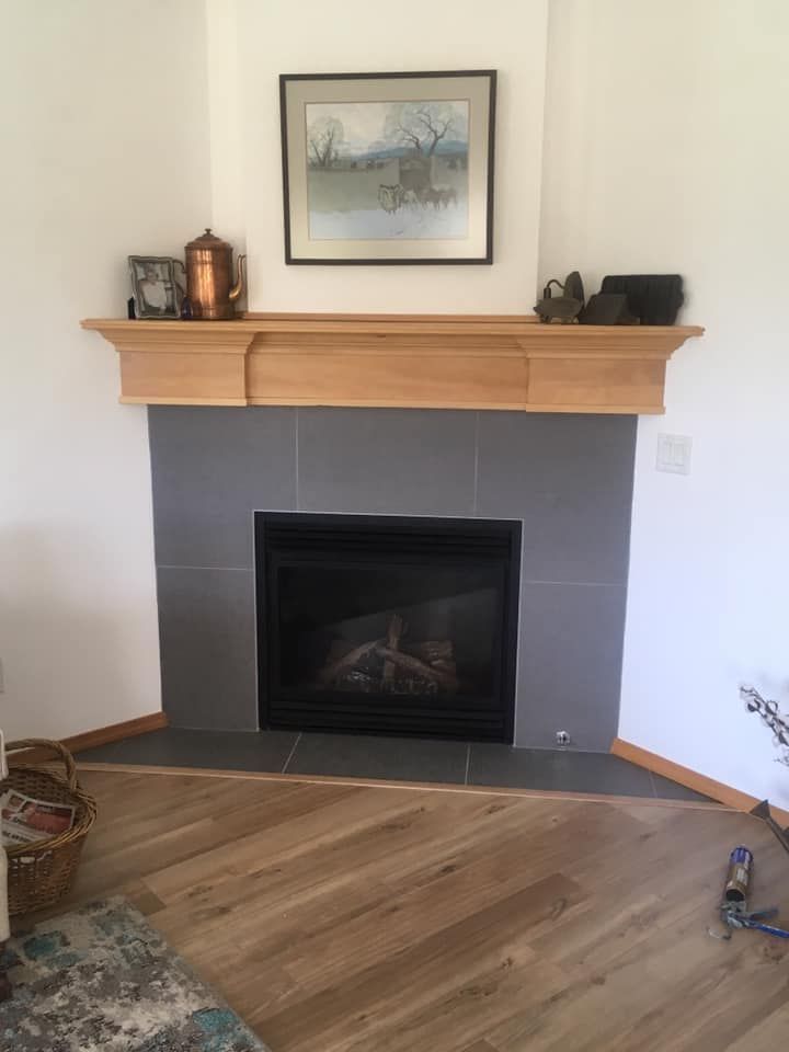 A living room with a fireplace and a picture on the wall above it.