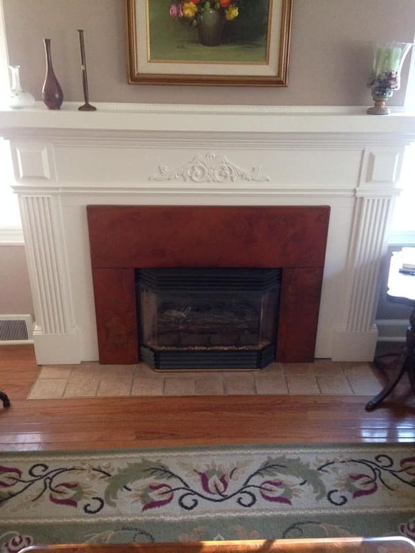 A living room with a fireplace and a rug.