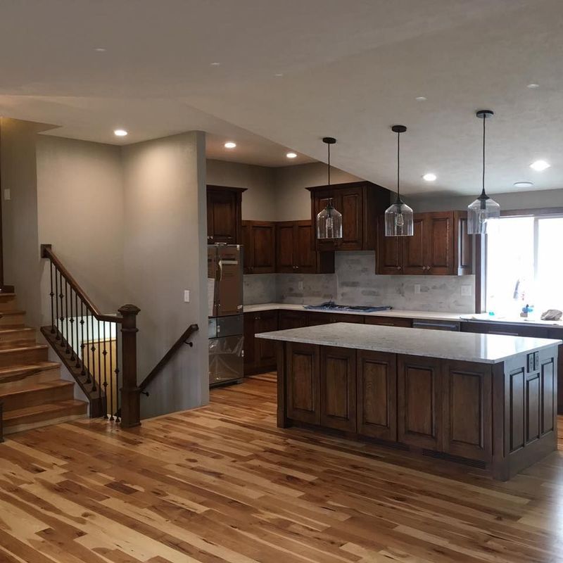 A kitchen with wooden cabinets and a large island