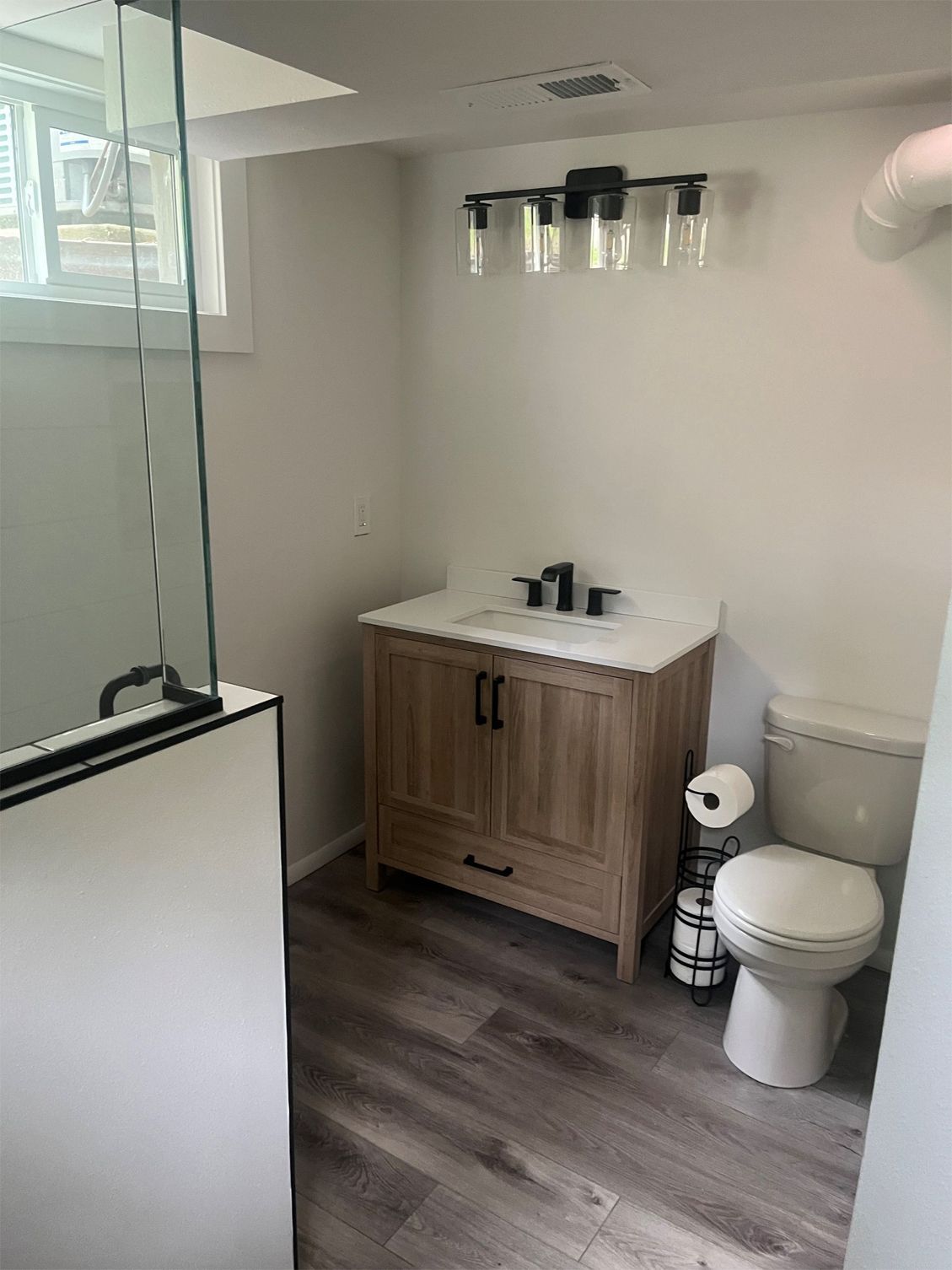 A bathroom with a sink, toilet, and shower.