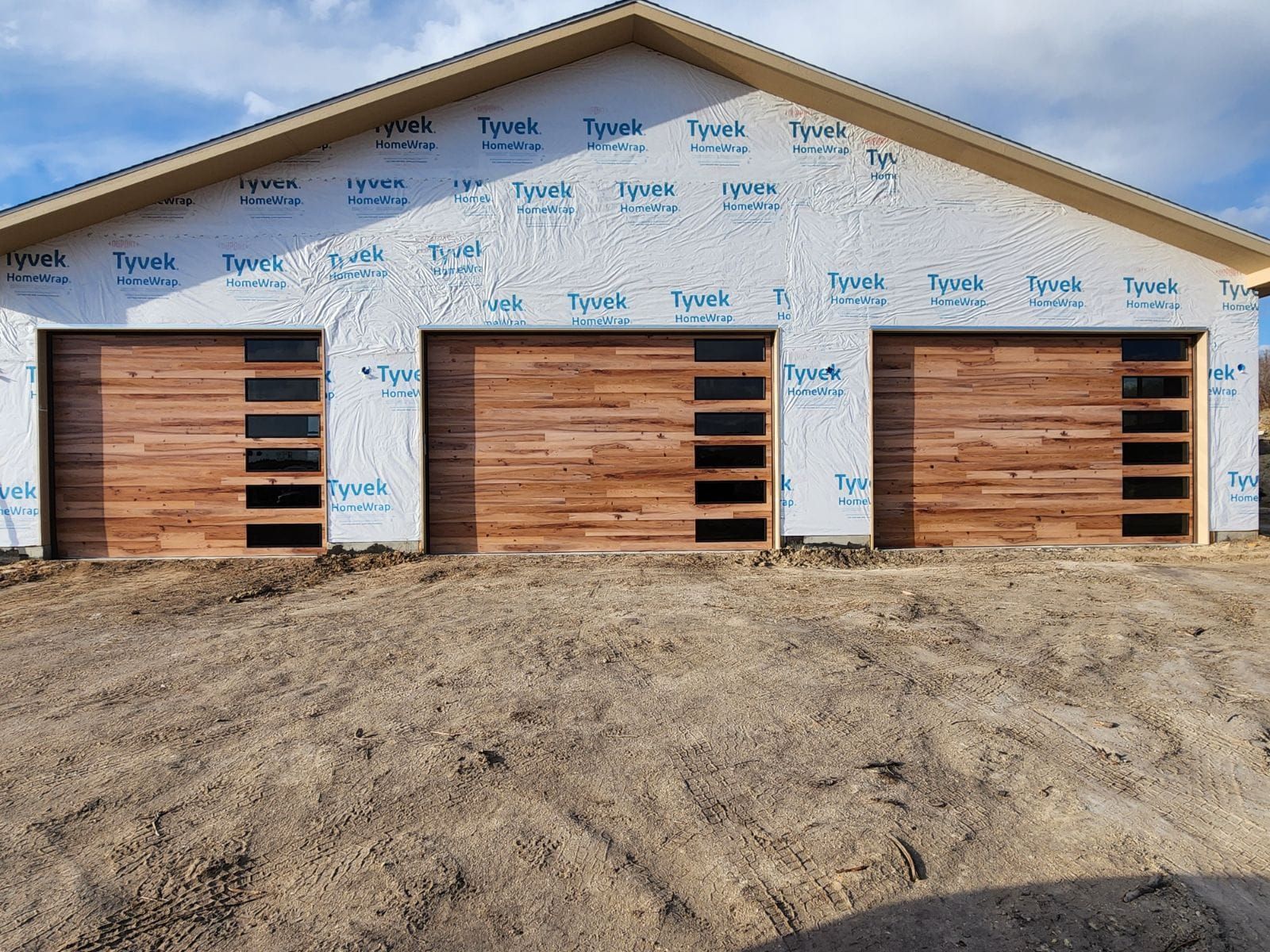 A house is being built with wooden garage doors.