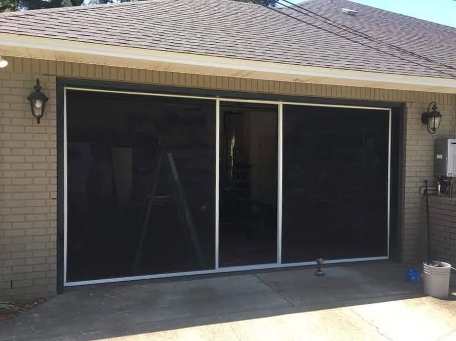 A brick house with a screened in garage door.