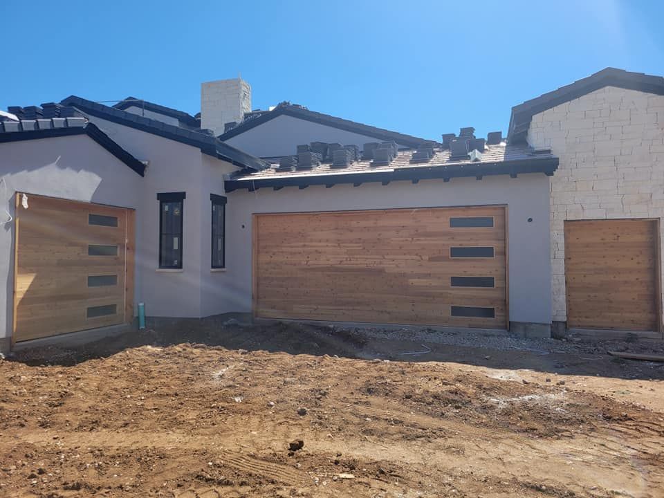 A house under construction with two wooden garage doors