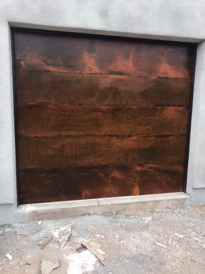 A brown garage door is sitting on the side of a building.